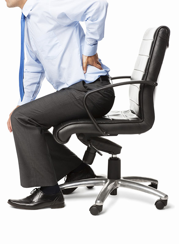Midsection of businessman with backache sitting in an office chair. Vertical shot. Isolated on white.